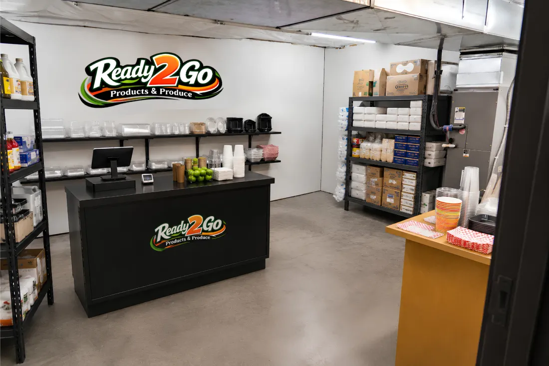 Inside the Ready 2 Go Products and Produce showroom in Yakima, WA, logo on the wall, product shelves behind the pickup counter